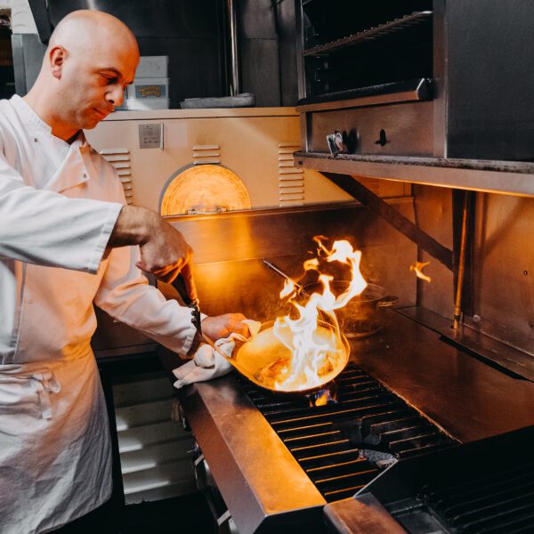 Chef cooking over open flames at Florios